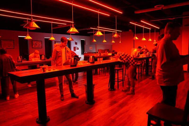 students practicing triangulations under red lighting during a q grader exam